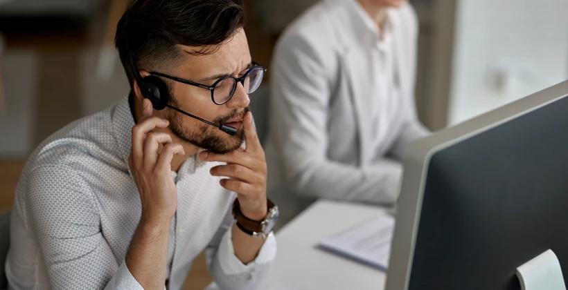 concentrated-call-center-agent-talking-with-a-customer-while-working-in-the-office 1.png